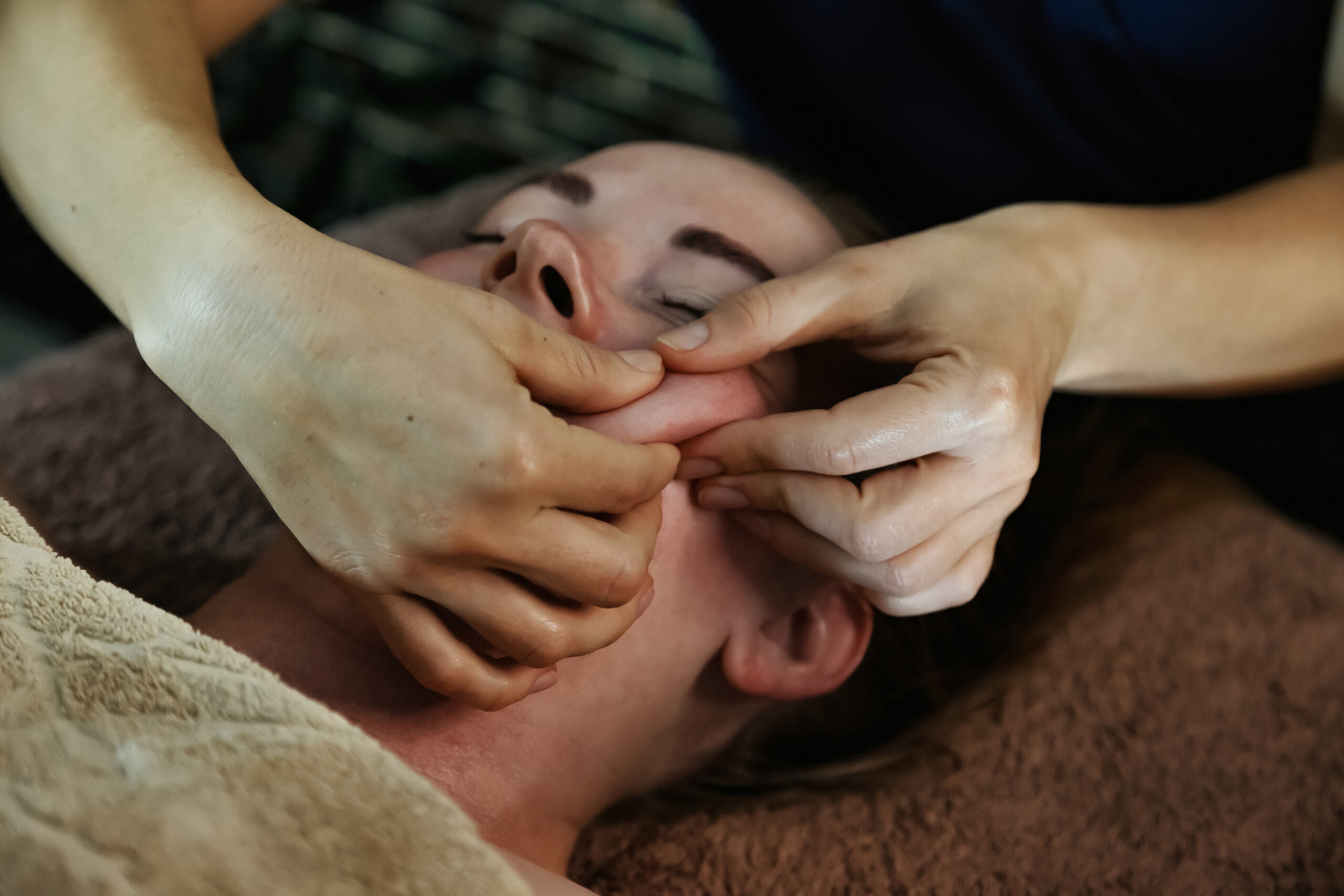 Inside a tranquil spa salon, a professional gives a rejuvenating facial massage. The warm ambiance promotes relaxation as the client enjoys a soothing treatment tailored to relieve stress.